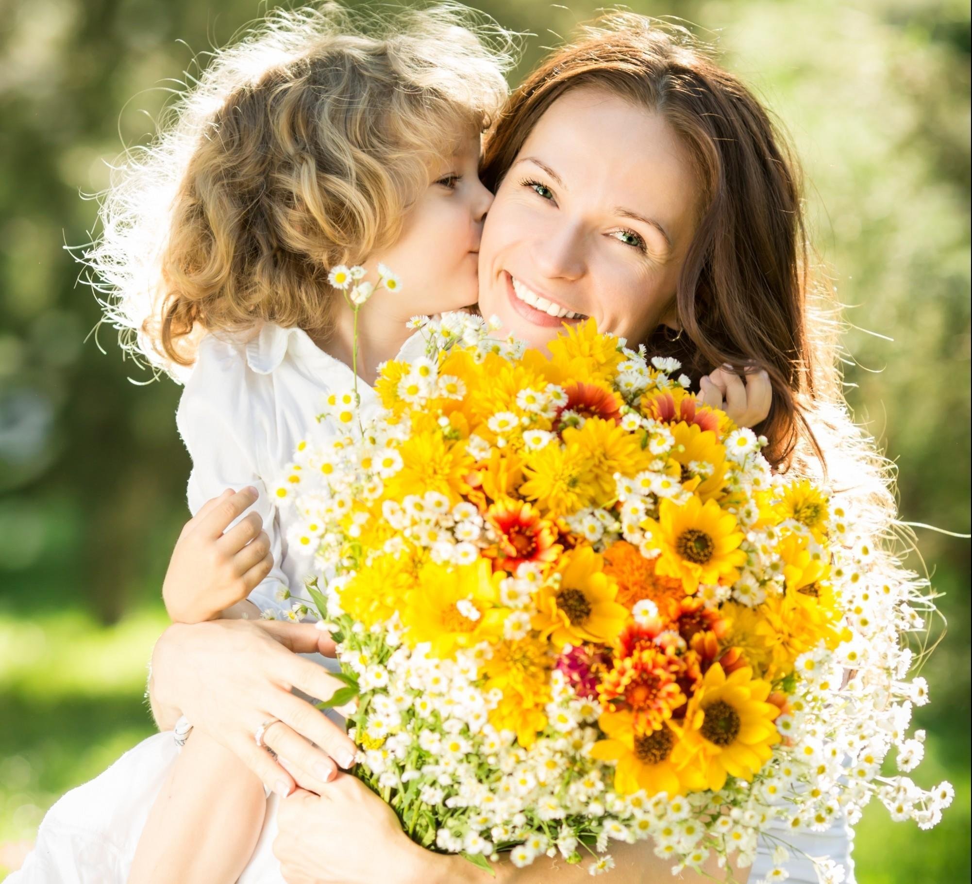 Ребенок дарит цветы маме. День матери. Мама с цветами и детьми. Букет для мамы.